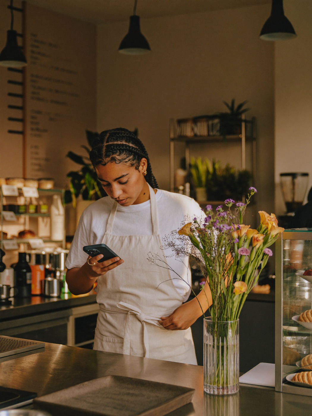 Barista de cafetería registrando su entrada por WhatsApp antes de abrir