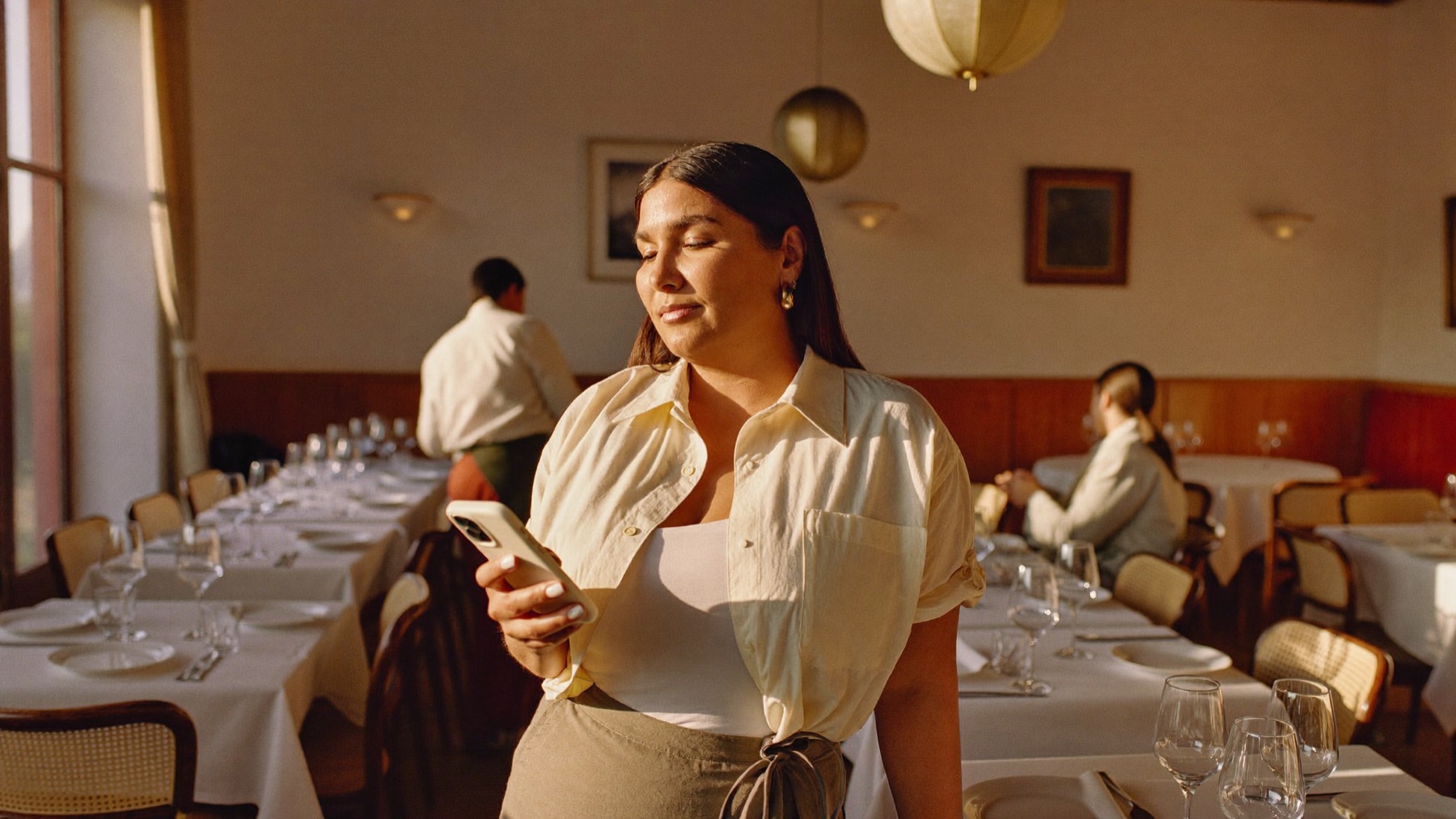 Dueña de restaurante revisando el día de su equipo desde el teléfono